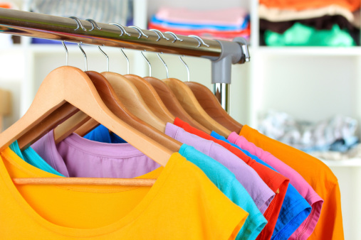 Variety of casual t-shirts on wooden hangers